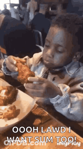 A Young Boy Is Sitting At A Table Eating Fried Chicken With A Fork . GIF