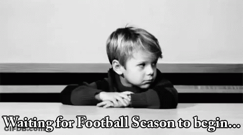A Young Boy Is Sitting At A Table Waiting For Football Season To Begin . GIF