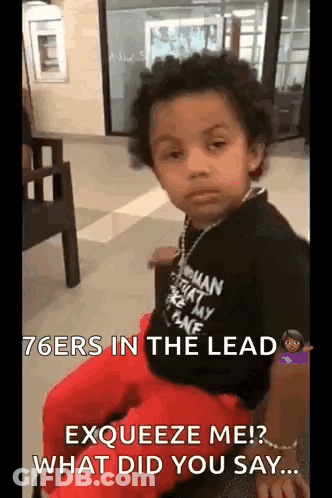 A Young Boy Is Sitting In A Chair In A Waiting Room With A Necklace Around His Neck . GIF