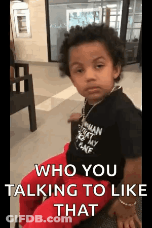 A Young Boy Is Sitting In A Chair With A Necklace Around His Neck And Says `` Who You Talking To Like That '' . GIF