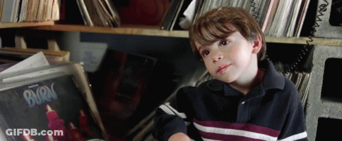 A Young Boy Is Sitting In Front Of A Burn Record GIF