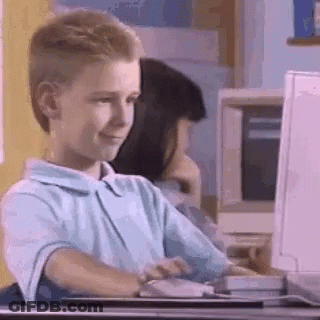 A Young Boy Is Sitting In Front Of A Computer . GIF