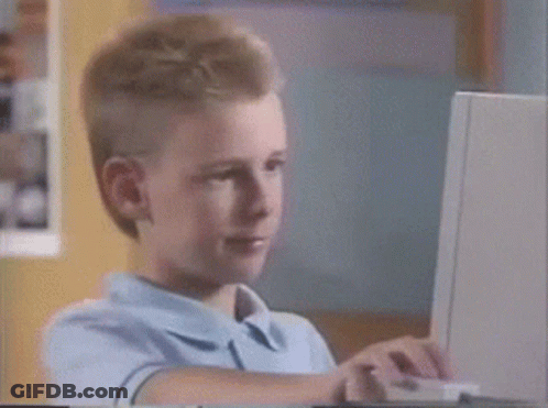 A Young Boy Is Sitting In Front Of A Laptop Computer GIF
