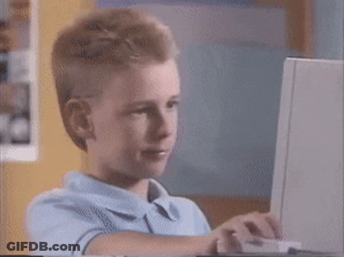 A Young Boy Is Sitting In Front Of A Laptop Computer GIF