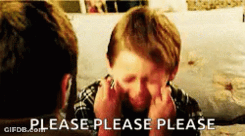 A Young Boy Is Sitting In Front Of A Man Covering His Face With His Hands . GIF