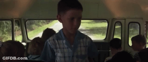 A Young Boy Is Sitting In The Back Of A School Bus GIF