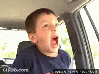 A Young Boy Is Sitting In The Back Seat Of A Car With His Mouth Wide Open . GIF