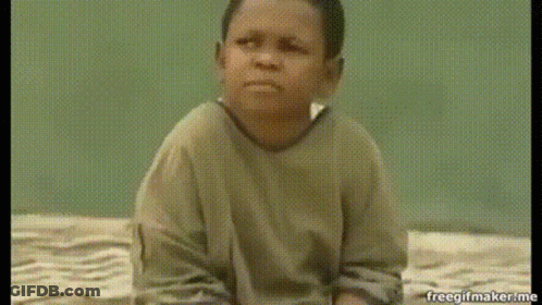 A Young Boy Is Sitting On A Bed And Making A Face . GIF