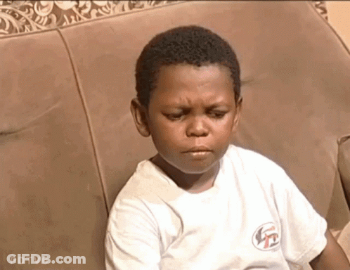 A Young Boy Is Sitting On A Couch With His Eyes Closed GIF