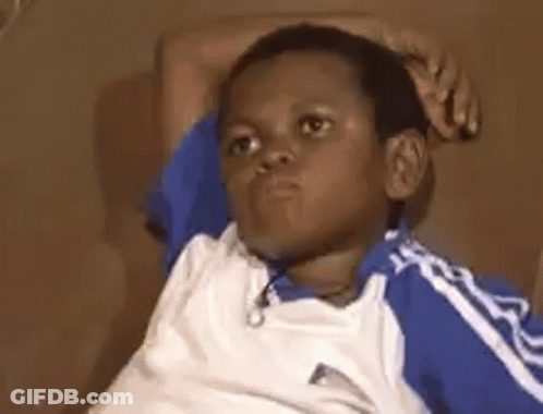 A Young Boy Is Sitting On A Couch With His Hands On His Head And Making A Funny Face . GIF