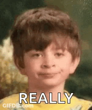A Young Boy Is Smiling And Making A Funny Face With The Words `` Really '' Written On His Face . GIF