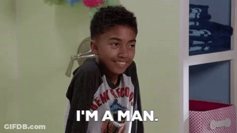 A Young Boy Is Smiling And Saying I 'M A Man GIF
