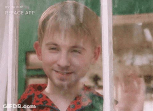 A Young Boy Is Smiling While Looking Out A Window . GIF