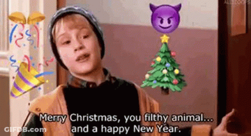 A Young Boy Is Standing In Front Of A Christmas Tree . GIF
