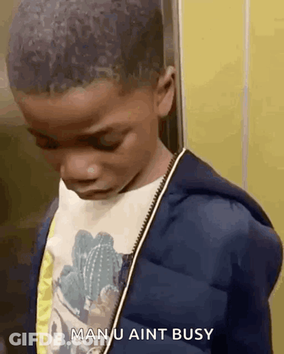 A Young Boy Is Standing Next To A Yellow Wall And Says Man U Aint Busy GIF
