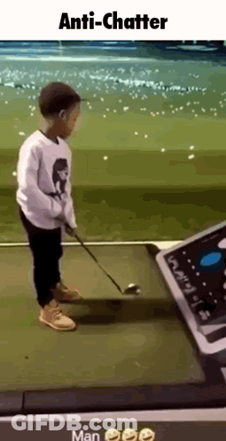A Young Boy Is Swinging A Golf Club On A Golf Course While Wearing A Face Mask . GIF