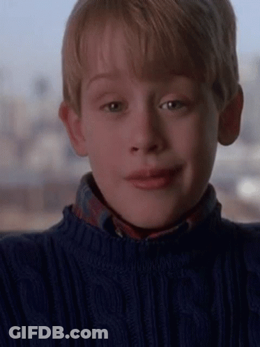 A Young Boy Is Wearing A Blue Sweater And A Plaid Shirt . GIF