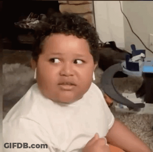 A Young Boy Is Wearing Headphones And Making A Funny Face While Sitting On The Floor . GIF