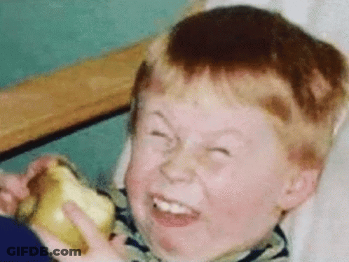 A Young Boy Making A Funny Face While Holding An Apple GIF