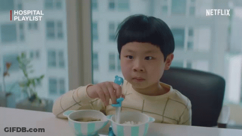 A Young Boy Sitting At A Table With A Bowl Of Food And A Netflix Logo GIF