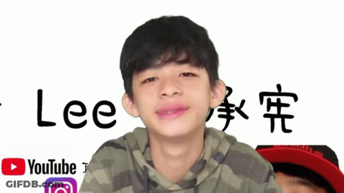 A Young Boy Stands In Front Of A Sign That Says Lee GIF
