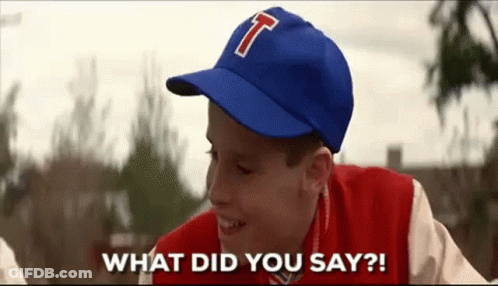 A Young Boy Wearing A Baseball Cap With The Letter T On It Is Smiling And Asking What Did You Say . GIF