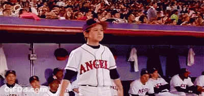 A Young Boy Wearing A Baseball Uniform With The Word Angel On It GIF