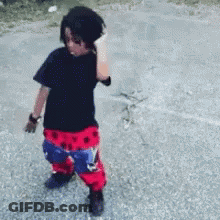 A Young Boy Wearing A Black Shirt And Red And Blue Pants GIF