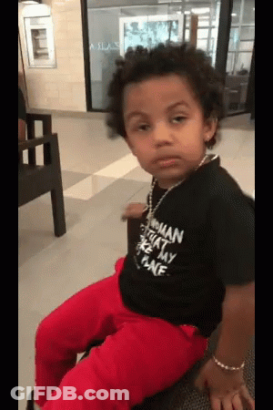 A Young Boy Wearing A Black Shirt That Says Woman On The Front GIF