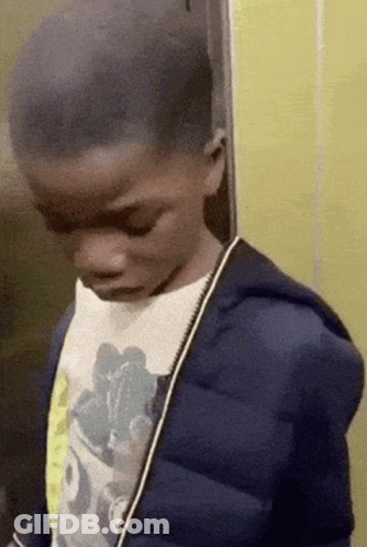 A Young Boy Wearing A Blue Jacket And A Mickey Mouse Shirt GIF