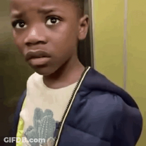 A Young Boy Wearing A Blue Jacket And A White Shirt Is Making A Funny Face . GIF