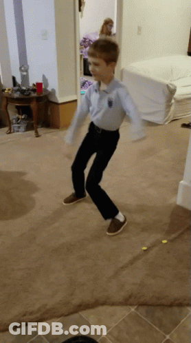 A Young Boy Wearing A Blue Shirt And Black Pants Is Jumping In The Air GIF