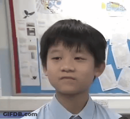 A Young Boy Wearing A Blue Shirt And Tie Is Sitting In Front Of A Bulletin Board . GIF