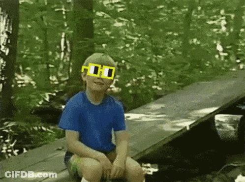A Young Boy Wearing A Blue Shirt And Yellow Sunglasses GIF