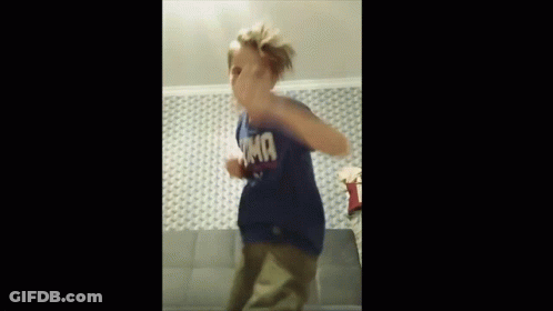 A Young Boy Wearing A Blue T-Shirt With The Word Tmf On It Is Dancing On A Couch . GIF