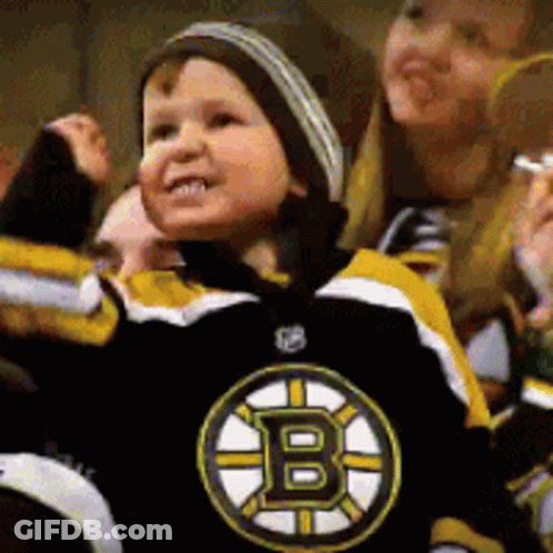 A Young Boy Wearing A Boston Bruins Jersey Is Cheering GIF