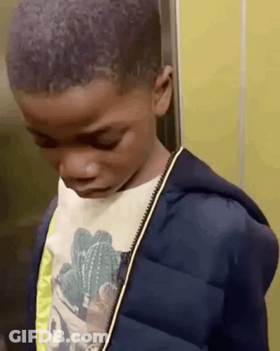 A Young Boy Wearing A Cactus Shirt And A Blue Jacket Is Standing In An Elevator Looking Down . GIF