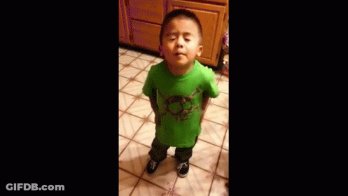 A Young Boy Wearing A Green Shirt Is Standing On A Tiled Floor . GIF