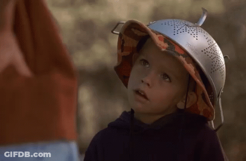 A Young Boy Wearing A Hat And A Strainer On Top Of His Head GIF