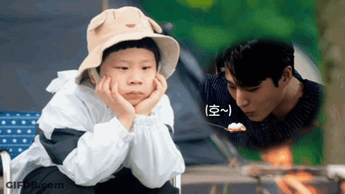A Young Boy Wearing A Hat Is Sitting Next To A Man Eating Rice GIF