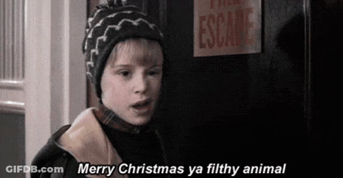A Young Boy Wearing A Hat Is Standing In Front Of A Door . GIF