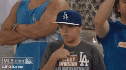 A Young Boy Wearing A La Hat And A Mlb.com Shirt GIF
