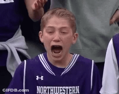 A Young Boy Wearing A Purple Basketball Jersey Is Crying While Sitting In The Stands . GIF