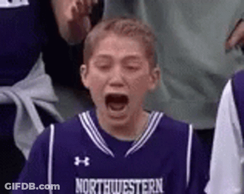 A Young Boy Wearing A Purple Basketball Jersey Is Screaming While Watching A Game . GIF