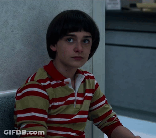 A Young Boy Wearing A Red And White Striped Shirt Looks At The Camera GIF