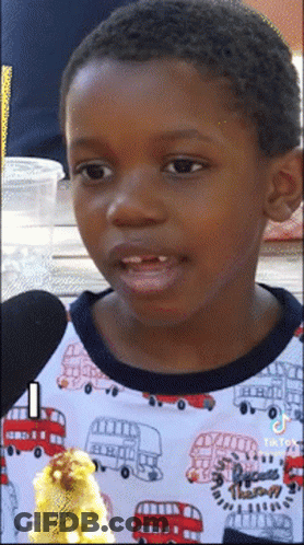 A Young Boy Wearing A Shirt With A Double Decker Bus On It GIF