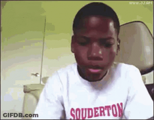 A Young Boy Wearing A Souderton T-Shirt Is Making A Funny Face . GIF