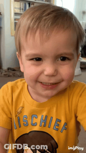 A Young Boy Wearing A Yellow Shirt That Says ' Mischief ' On It GIF