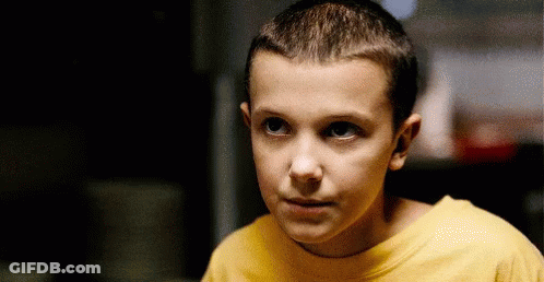 A Young Boy Wearing A Yellow T-Shirt Is Looking At The Camera . GIF