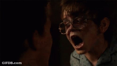 A Young Boy Wearing Glasses And A Blue Shirt Is Looking At Another Boy . GIF